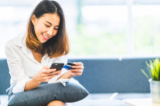 A person using their mobile device to research the differences between an inbound vs outbound call center