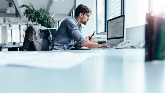 a person using their computer to research the differences between an inbound vs outbound call center