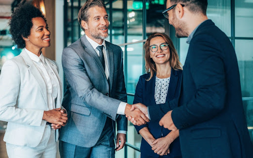 Business owners shake hands with their onshore call center outsourcing partners.