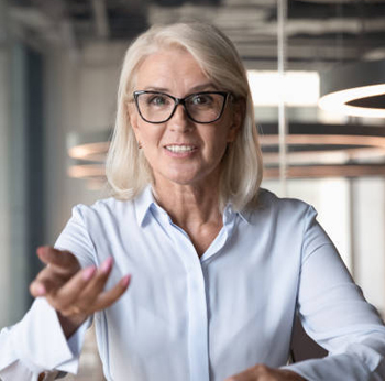 older woman gesturing at camera