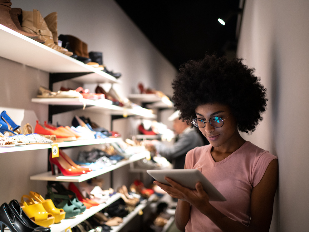 a person inside of a shoe store working on an ipad