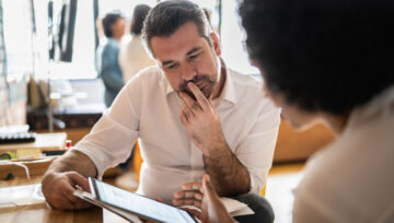 2 colleagues reviewing call center quality assurance metrics on a tablet