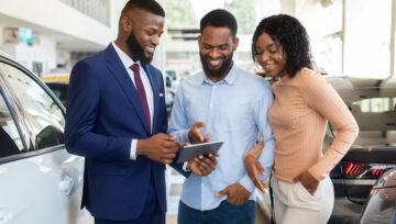 car salesman learning how to improve customer satisfaction while working in a showroom