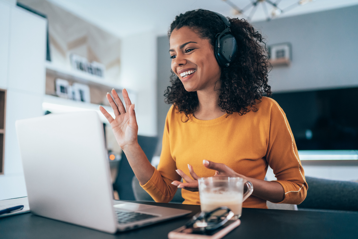 a person at their computer, wearing a headset researching information about customer orientation