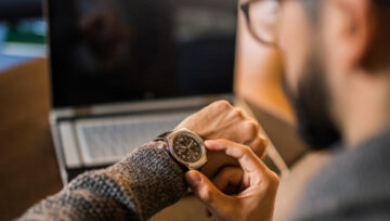 a person checking their watch, tracking their call center's average handle time.