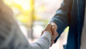 two people shaking hands as they work on building customer relationships