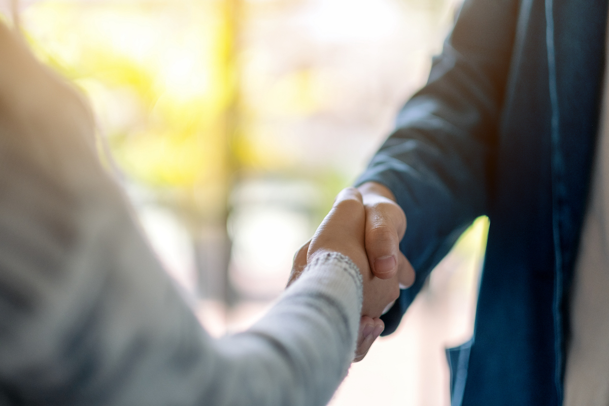 two people shaking hands as they work on building customer relationships