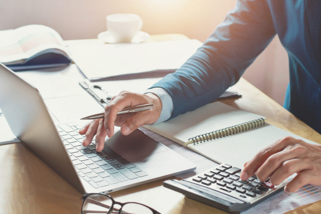 a person at a desk working on ways they can save their business money