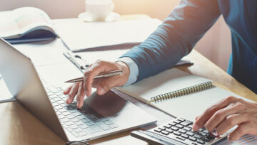 a person at a desk working on ways they can save their business money