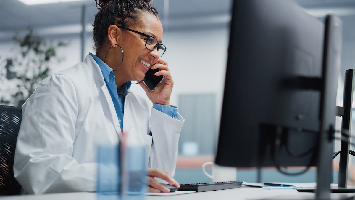 a doctor in a lab coat at their computer learning about HIPAA compliant call centers