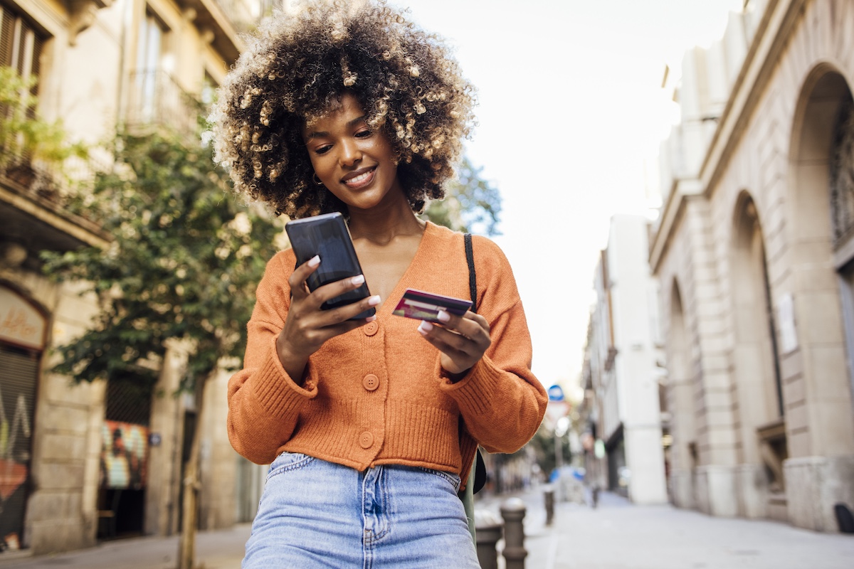 a person benefiting from a luxury retail brand's clienteling strategy while they make a purchase using their credit card outdoors