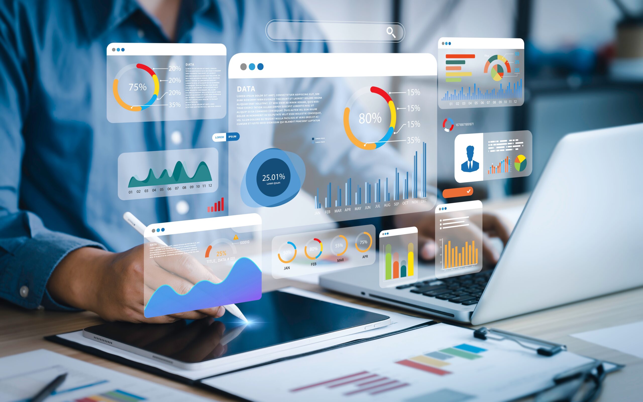 Analyst viewing a data dashboard with computer and smart pad.