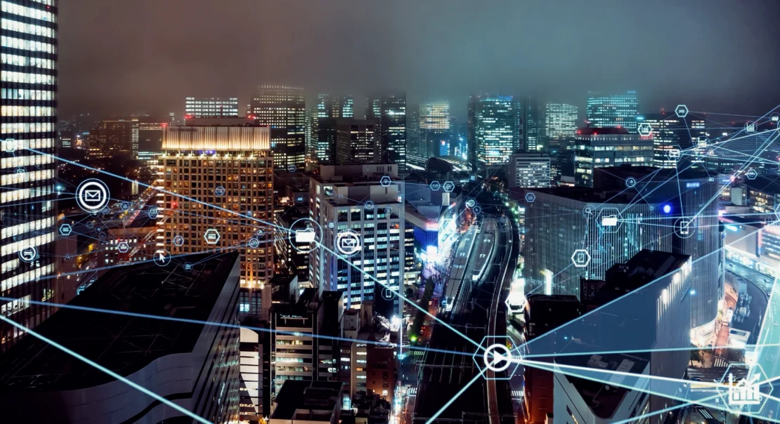 Buildings in an evening city are connected with a web of outsourced call center communication channels.