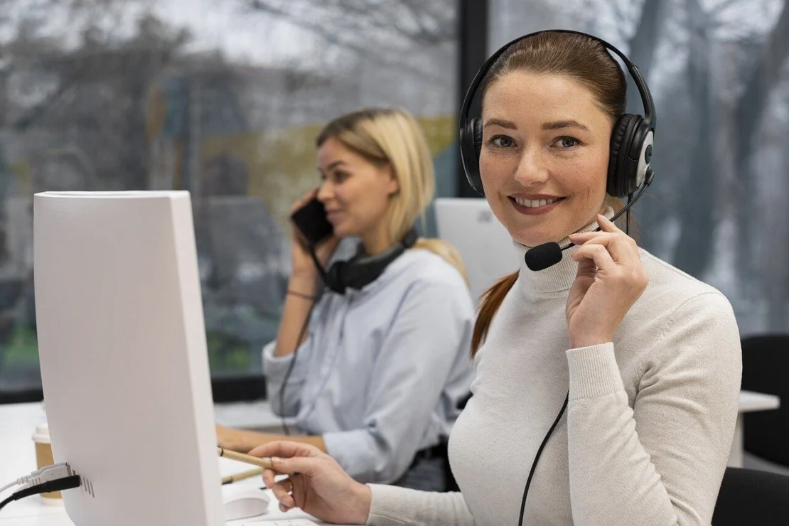 Smiling woman wearing headset at desk in call center