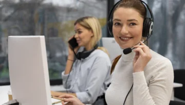 Smiling woman wearing headset at desk in call center