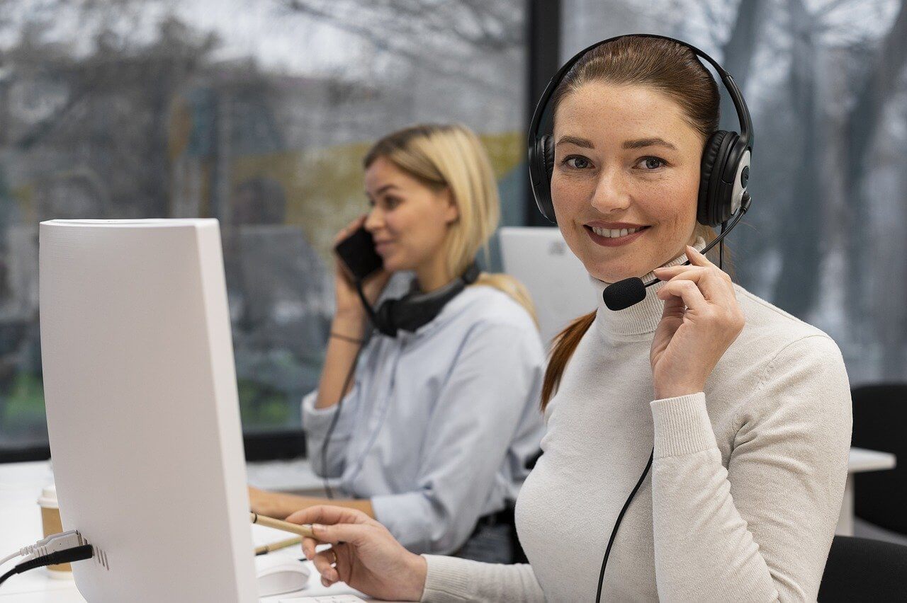 Smiling woman wearing headset at desk in call center
