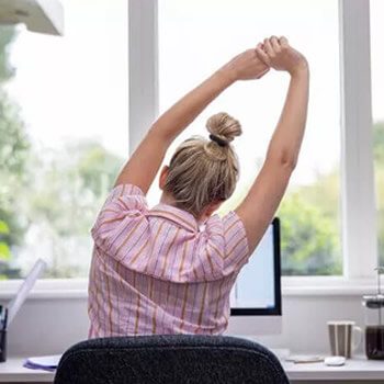 Call Center outsourcing agent stretching at their desk