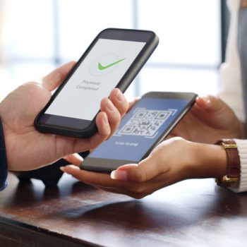 Customer using phone for payment at cafe restaurant, cashless QR code technology and money transfer concept