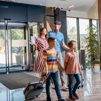a family entering a hotel after having a positive experience with an outsourced hospitality contact center
