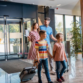 a family entering a hotel after having a positive experience with an outsourced hospitality contact center