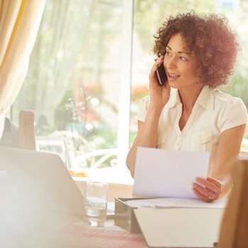 woman on the phone holding a bill
