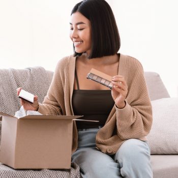 woman pulling makeup out of cardboard box