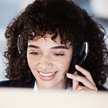 a PCI compliant call center agent wearing a headset, speaking to a customer.