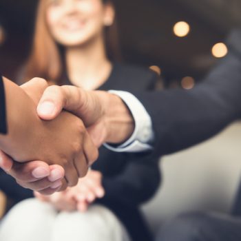 2 business partners shaking hands after making the decision to use a PCI compliant call center