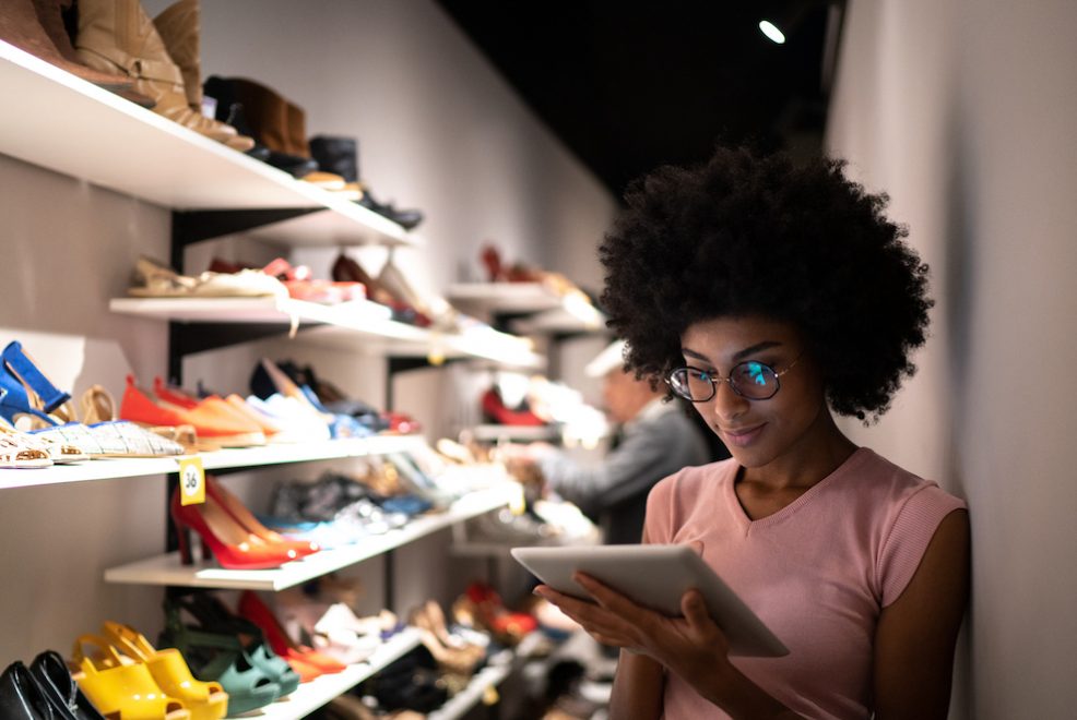 a person inside of a shoe store working on an ipad